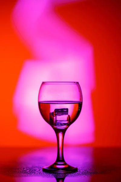 A glass with a drink on a beautiful red background illuminated w — ストック写真