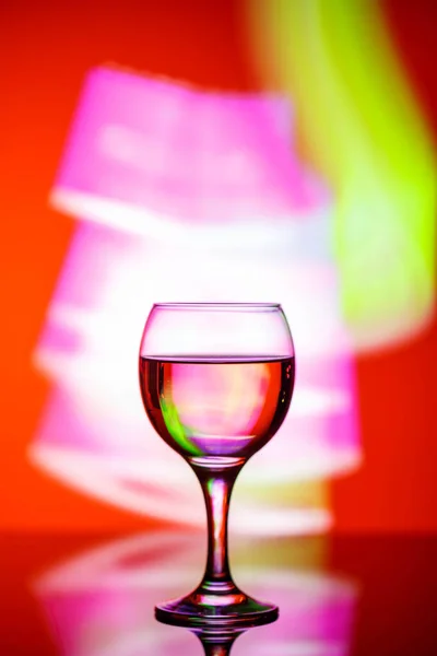 A glass with a drink on a beautiful red background illuminated w — ストック写真