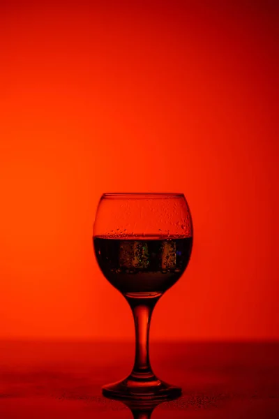 Champagne glass on red beautiful background on black glass — ストック写真