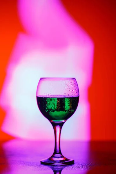 A glass with a drink on a beautiful red background illuminated w — ストック写真