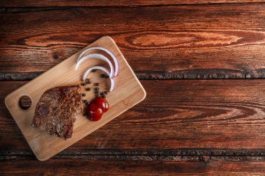 Baharatlı ızgara et ve aşınmış ahşap bir sırt üzerinde domates sosu.