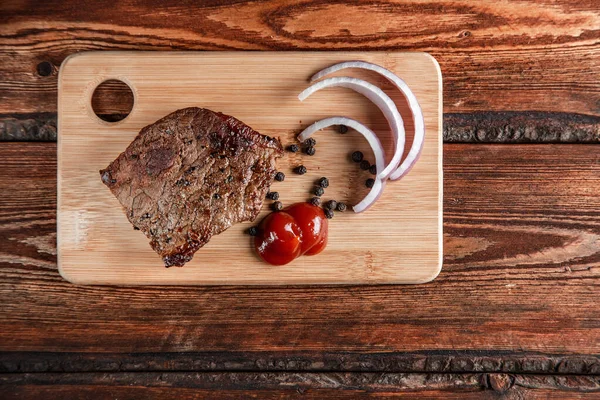 Gegrilltes Fleisch mit Gewürzen und Tomatensauce auf einem abgewetzten Holzrücken — Stockfoto