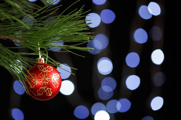 Weihnachtsspielzeug auf einem Fichtenzweig auf dem Hintergrund eines Bäumchens — Stockfoto