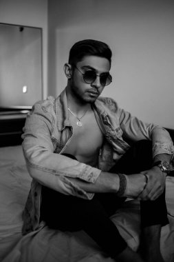 Yatakta kot ceketli şık bir genç var. siyah ve beyaz ph