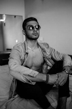 Yatakta kot ceketli şık bir genç var. siyah ve beyaz ph