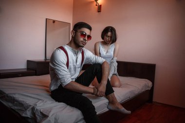 Gözlüklü genç bir adam ve birlikte oturan genç bir kız.