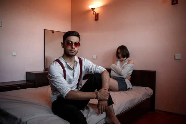 Un chico joven y elegante en gafas y una chica joven sentados juntos —  Fotos de Stock