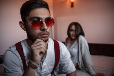 Güneş gözlüklü, kara kara kara düşünen esmer bir adamın yakın plan portresi.. 