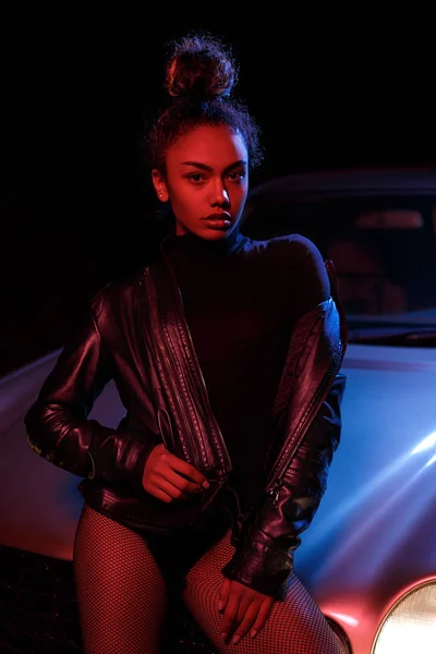 Una joven hermosa afro-americana en una chaqueta de cuero, en un b — Foto de Stock