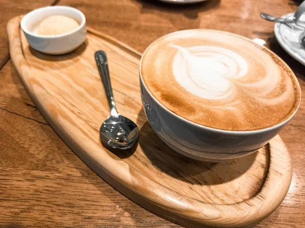 Cappuccino dalam cangkir keramik putih di atas nampan kayu. fo selektif — Stok Foto