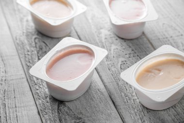 Tahta arka planda farklı türde doğal organik yoğurt.