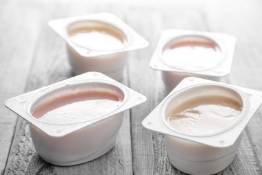 Tahta arka planda farklı türde doğal organik yoğurt.