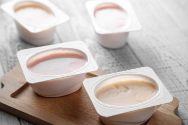 Tahta arka planda farklı türde doğal organik yoğurt.