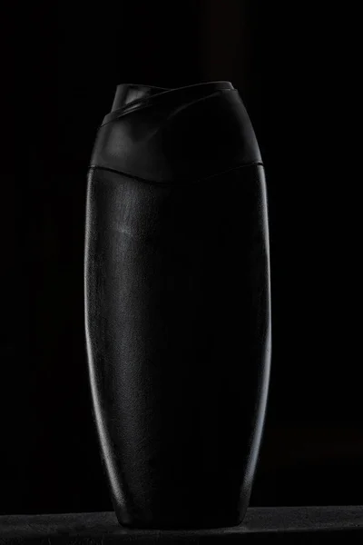 Garrafa de plástico preto para shampoo ou gel de chuveiro em preto isolado — Fotografia de Stock