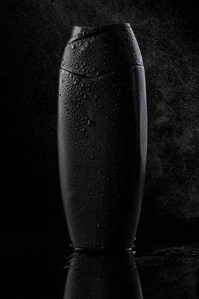 Garrafa de plástico suado preto para shampoo ou gel de banho em um preto — Fotografia de Stock