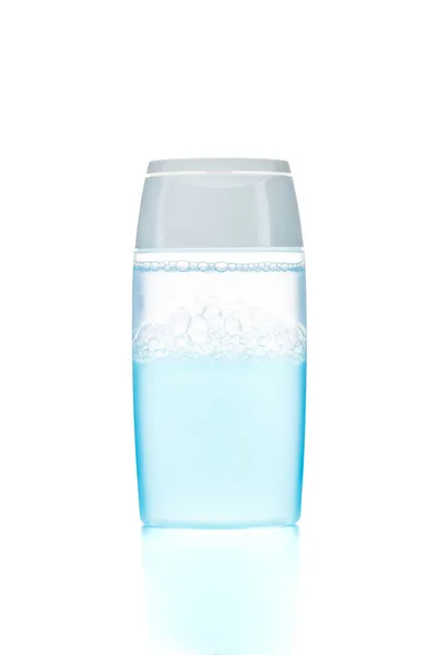 Transparante fles met blauwe gezichtsreiniger op een witte gel — Stockfoto