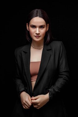 Siyah takım elbiseli zarif bir kadının yüksek moda portresi.