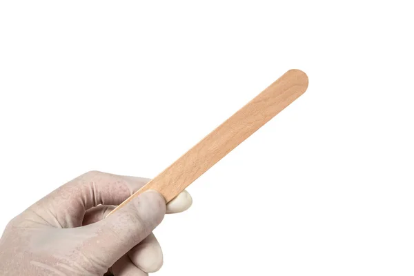 Kéz tartsa steril, eldobható környezetbarát, környezetbarát fa orvosi spatula célja, hogy vizsgálja meg a száj és a torok egy fehér, elszigetelt háttér — Stock Fotó