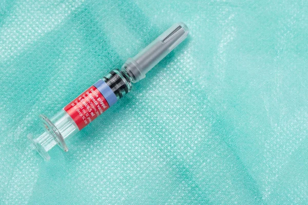Vacuna contra la gripe en una jeringa especial desechable. sobre un fondo verde médico — Foto de Stock