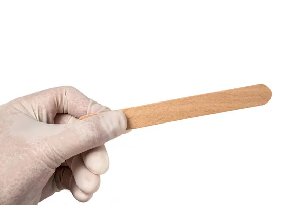 Mâinile țin o spatulă medicală sterilă de unică folosință ecologică din lemn concepută pentru examinarea gurii și gâtului pe un fundal alb izolat — Fotografie, imagine de stoc