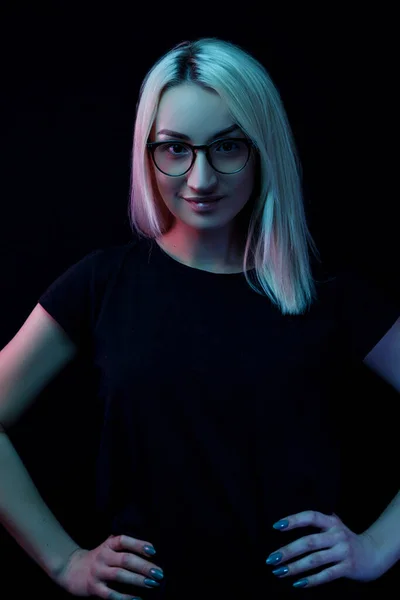 Улыбающаяся молодая белая блондинка в очках. портрет крупным планом в неоновом свете — стоковое фото