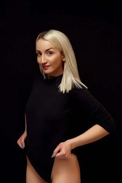 Young Caucasian beautiful blonde woman posing in a black bodysuit . — Stock Photo, Image