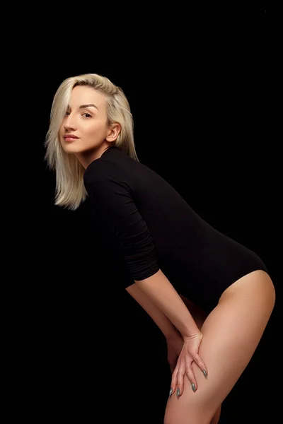 Young Caucasian beautiful blonde woman posing in a black bodysuit . — Stock Photo, Image