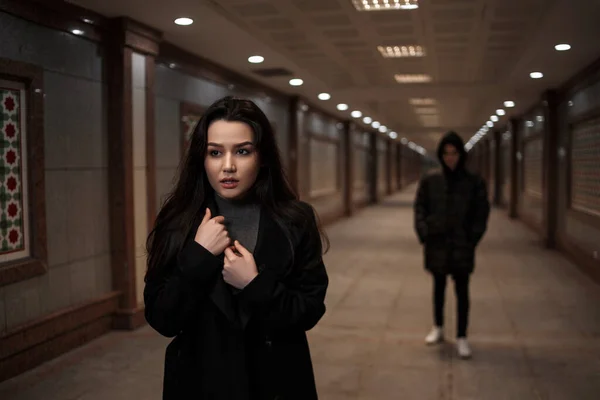 Genç ve güzel bir kadın gece vakti bir yeraltı geçidinde yürür. Peşinde de kafasında başlık olan koyu renk elbiseli bir adam.