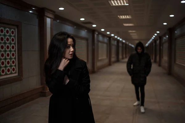 Genç ve güzel bir kadın gece vakti bir yeraltı geçidinde yürür. Peşinde de kafasında başlık olan koyu renk elbiseli bir adam.