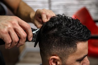 Koyu saçlı bir adamın yakın plan saç kesimi. Sinematik fotoğrafçılık.