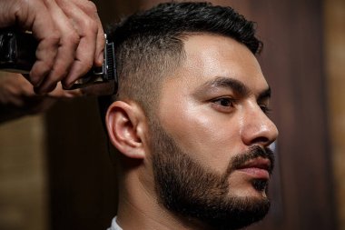 Adam, berber dükkanında saç kesiminde siyah saçlı bir Asyalı. Sinematik görüntü