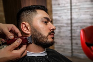 Adam, berber dükkanında saç kesiminde siyah saçlı bir Asyalı. Sinematik görüntü