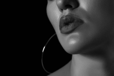 Siyah arka planda genç bir kızın siyah-beyaz dramatik portresi.