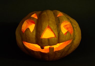 Cadılar Bayramı Balkabağı bir mum içinde. siyah arka plan üzerine