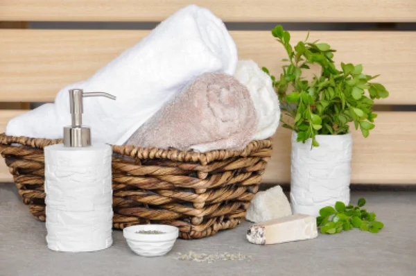 Sabun, herbal dan handuk dalam keranjang Wicker pada latar belakang cahaya — Stok Foto