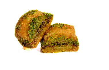 Antep fıstığı, ceviz ve beyaz zemin üzerine bal baklava.