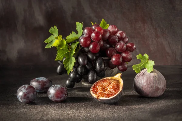 Natureza morta com frutas: uva, figo, ameixa no copo de estanho de cobre antigo — Fotografia de Stock