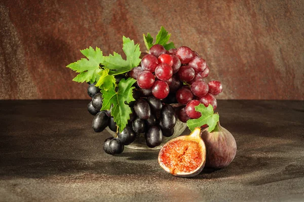 Natureza morta com frutos: uva, figo na xícara de estanho de cobre antiga — Fotografia de Stock