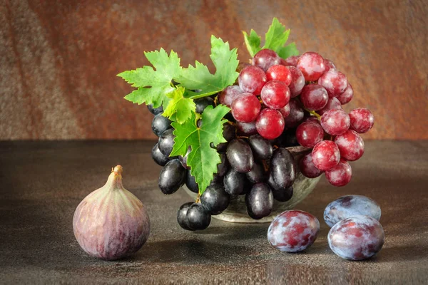 Natureza morta com frutas: uva, figo, ameixa no copo de estanho de cobre antigo — Fotografia de Stock