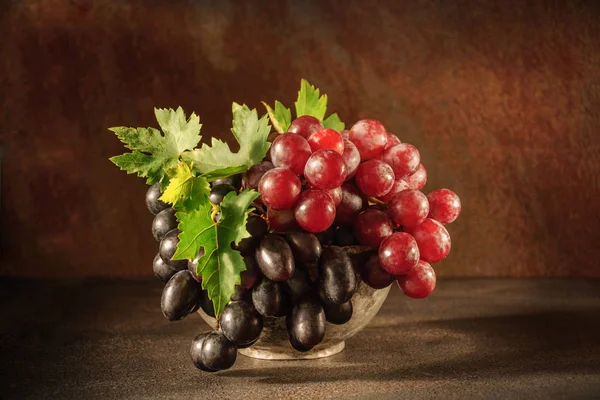 Natureza morta com uva no copo de cobre antigo — Fotografia de Stock