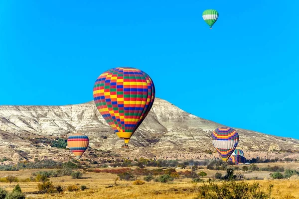 Globo de aire caliente volando sobre valles en Capadocia Turquía — Foto de Stock