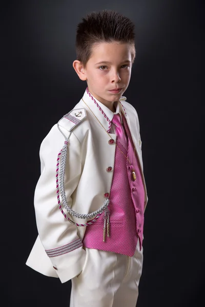 Jonge jongen staande op zoek ernstig in zijn eerste heilige communie — Stockfoto