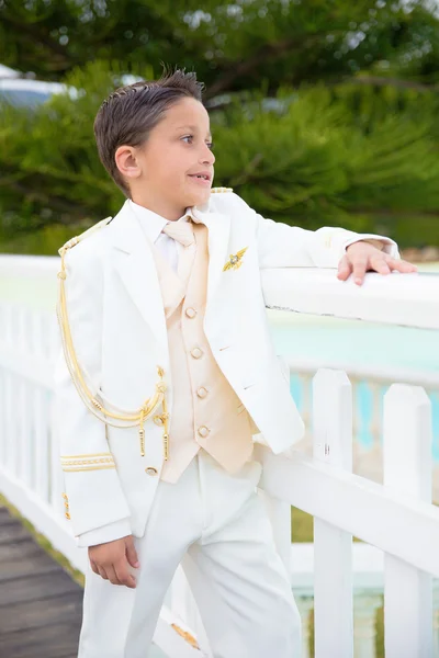 白い木製フェンスに寄りかかって若い最初の聖体拝領少年 — ストック写真