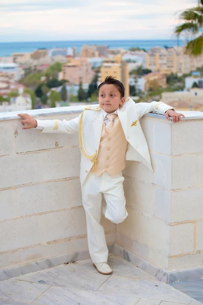 Jeune garçon première communion appuyé sur un mur Photo De Stock