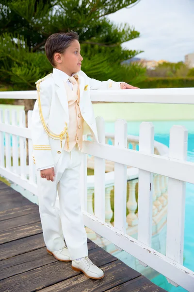 白い木製フェンスに傾いた若い最初の聖体拝領少年、 ロイヤリティフリーのストック写真