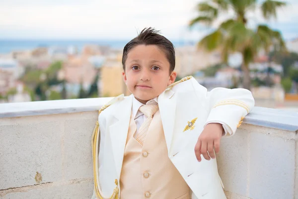 Young First Communion boy leaning on a wall with his elbow — Stock Photo, Image
