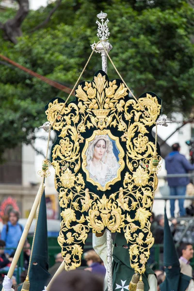 Holy Week in Malaga, Spain. Nazarenes holding a banner in Palm Sunday. — Stock Photo, Image