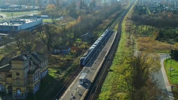 Osobní vlak - projíždějící vlakové nádraží - letecký záběr — Stock video