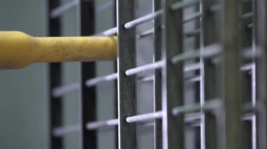 Sprey tabancayla metal çitleri boyayan adam.