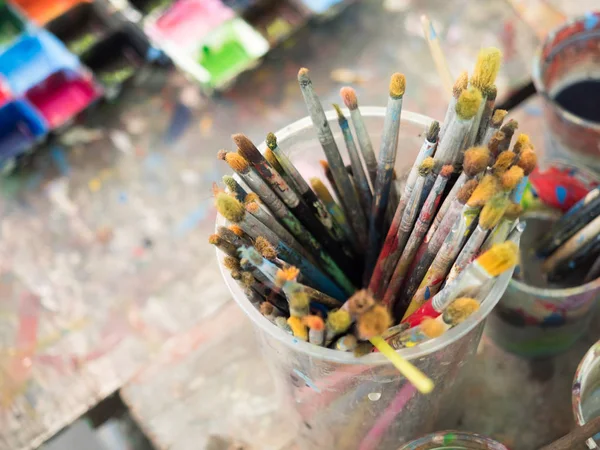 Dirty Paint Brushes in glass on the table
